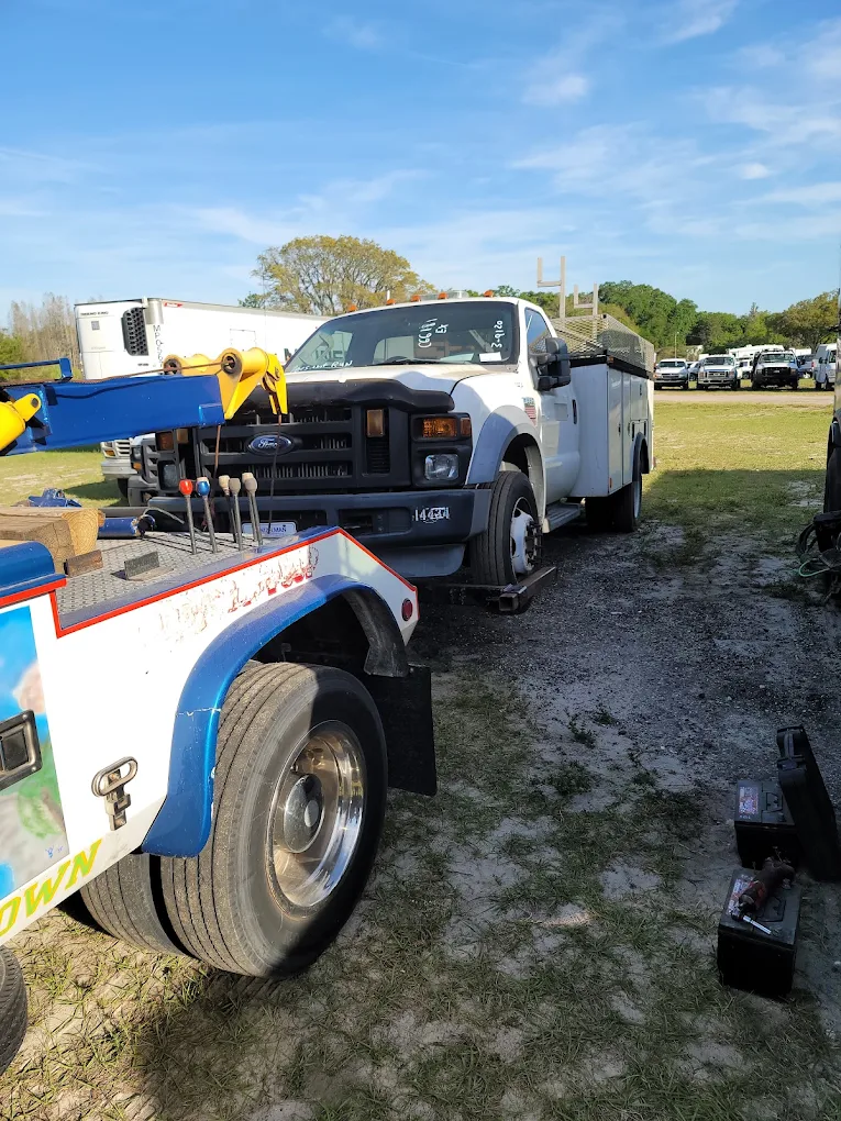 White Ford service truck with utility bed at outdoor equipment auction or sale event