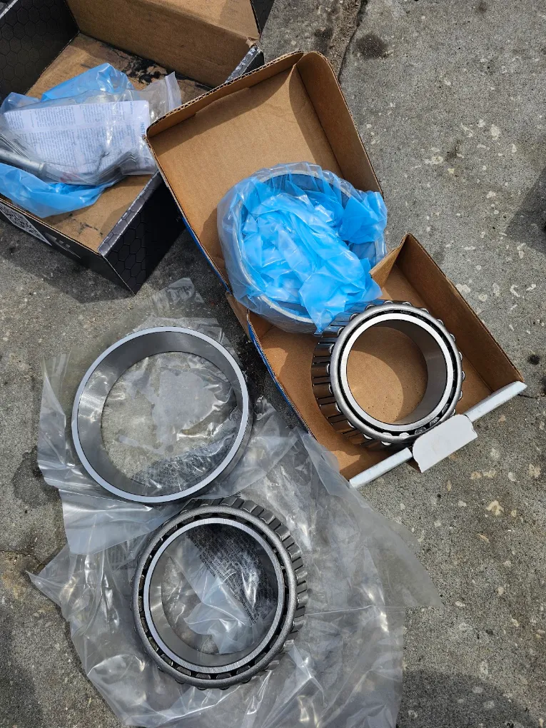 Industrial bearing parts in cardboard boxes and plastic packaging on concrete surface
